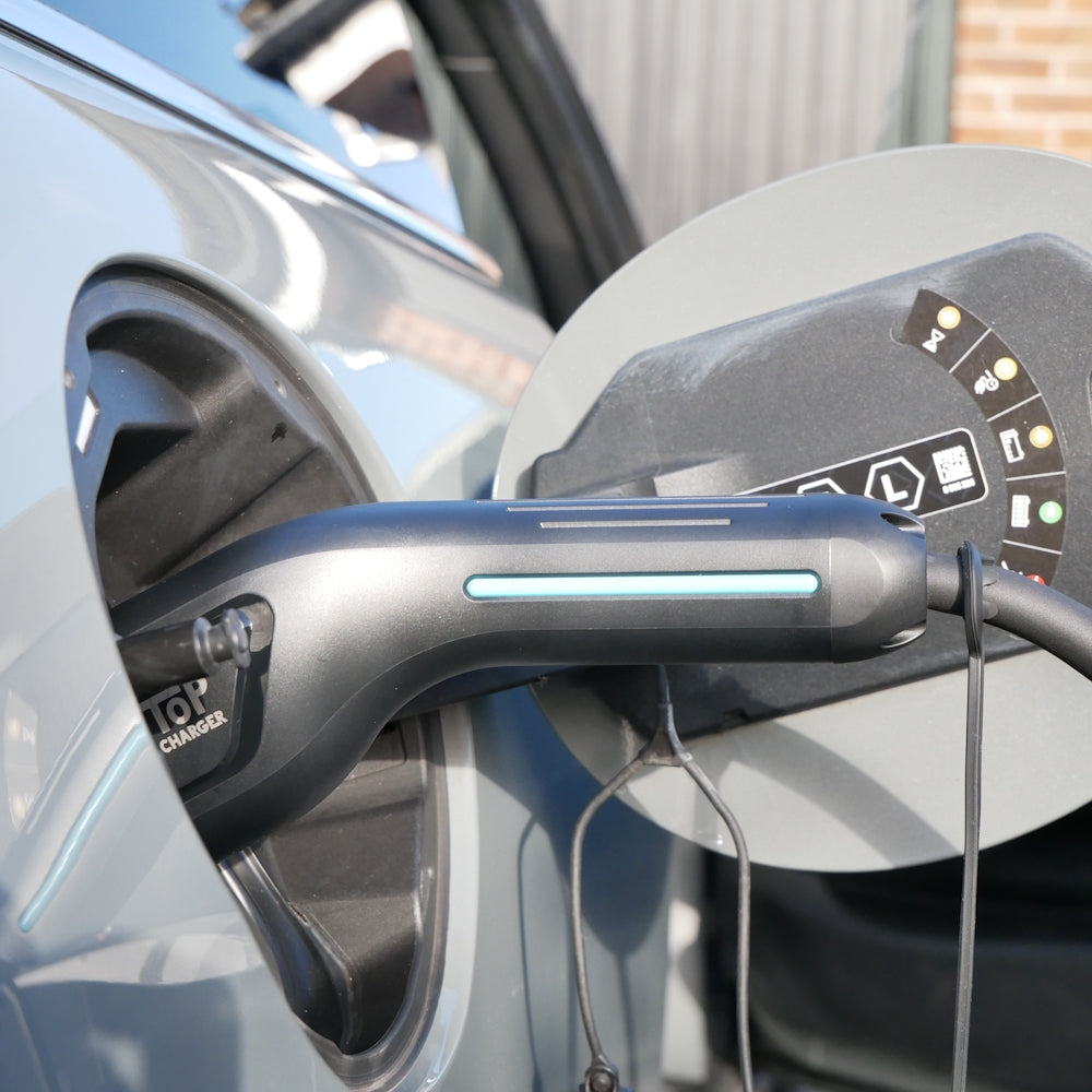 This image shows a safe EV cable from Top Charger plugged into an electric Mini
